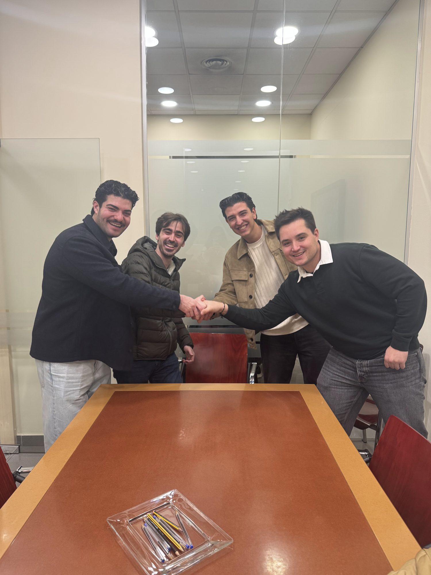 Jan, Alex, Marti y Raul, los cuatro amigos fundadores de Miari, dándose la mano